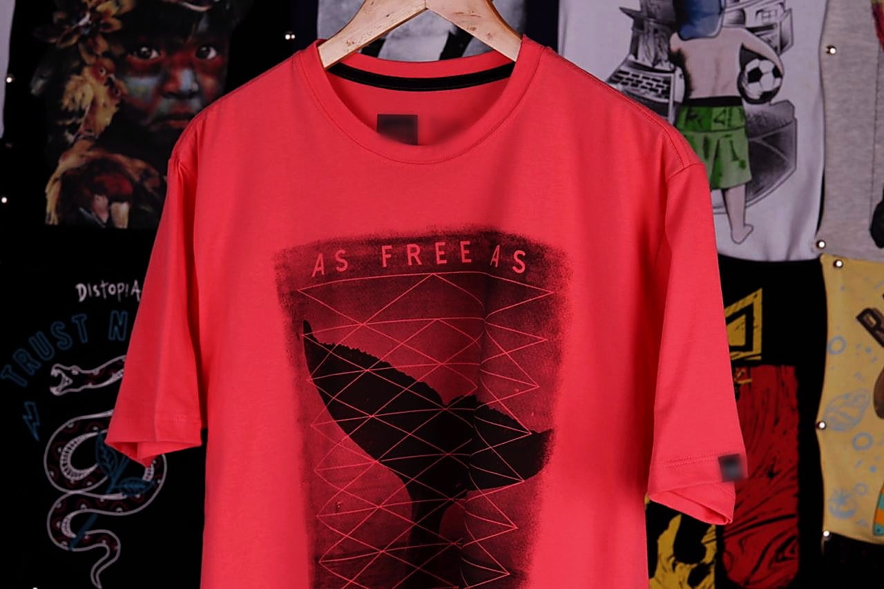 Camiseta estampada em destaque numa arara de camisetas — confecção e estamparia